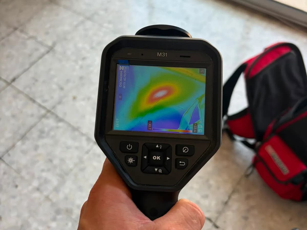 Technicien utilisant une caméra thermique sur le terrain pour localiser une fuite